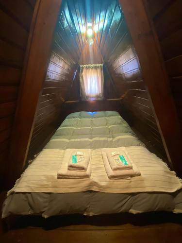 ein Bett in einem Zelt mit Handtüchern darauf in der Unterkunft Las Cabañitas in El Calafate