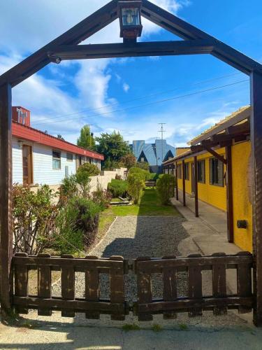 una entrada de madera a un edificio con una valla de madera en Las Cabañitas en El Calafate