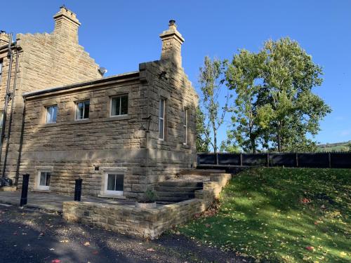 ein altes Steingebäude auf einem Feld in der Unterkunft Station House in Durham