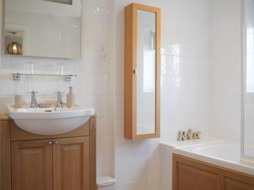 a white bathroom with a sink and a mirror at Meadow View in Harley