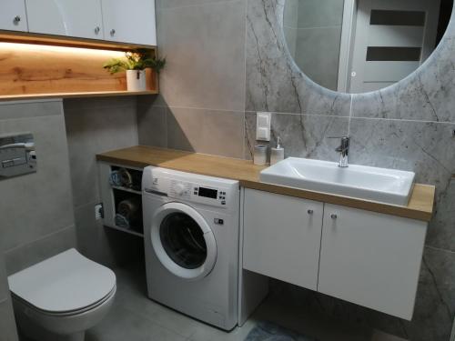 a bathroom with a washing machine and a sink at Apartament Zielone Wzgórze 2 in Jelenia Góra
