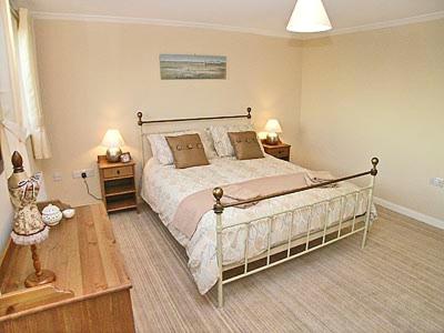 a bedroom with a large bed and two night stands at Breedsmoor Cottage in Ore