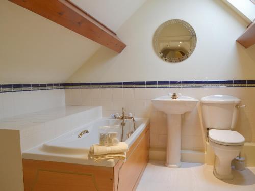 a bathroom with a sink toilet and a mirror at Swallows Nest in Crich