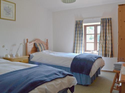 a bedroom with two beds and a window at Holly Bank in Crich