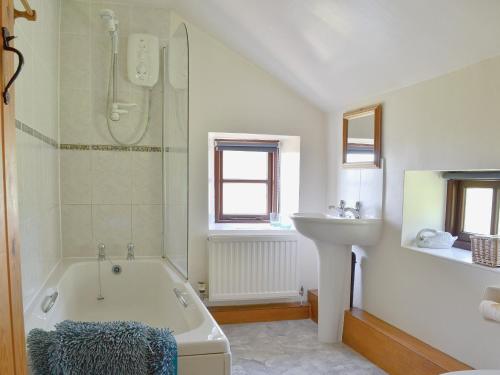 a bathroom with a bath tub and a sink at Holly Bank in Crich