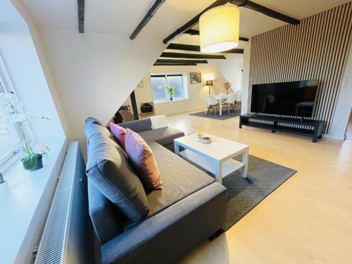 uma sala de estar com um sofá e uma mesa em aday - 3 bedrooms luxurious apartment in Svenstrup em Svenstrup