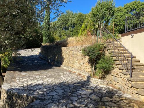 un escalier en pierre avec un escalier et un mur en pierre dans l'établissement En Provence, LE 89 Villa - 10 personnes, à Bagnols-sur-Cèze