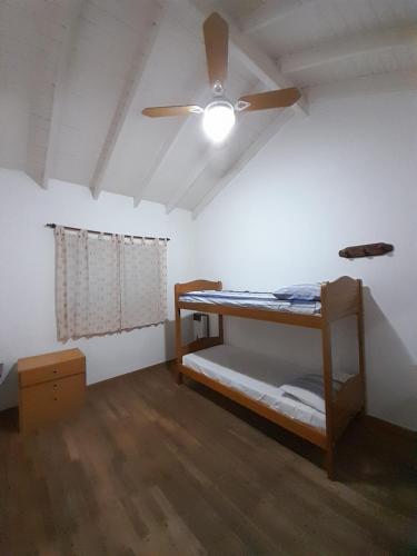 a room with two bunk beds and a ceiling fan at Casa Naranja in Merlo