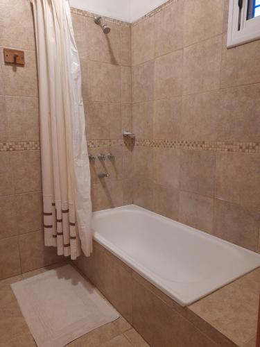 a bathroom with a shower with a white bath tub at Casa Naranja in Merlo