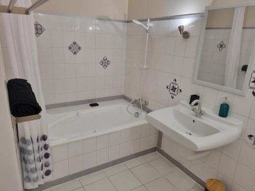 ein Bad mit einer Badewanne, einem Waschbecken und einer Dusche in der Unterkunft Pitaya in Claira