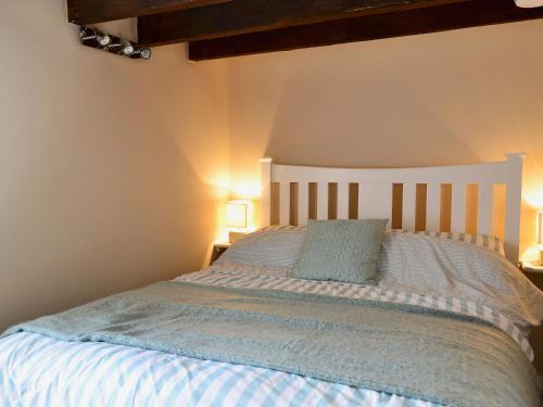 a bedroom with a large bed with two lamps at Rock Cottage in Saint Abbs