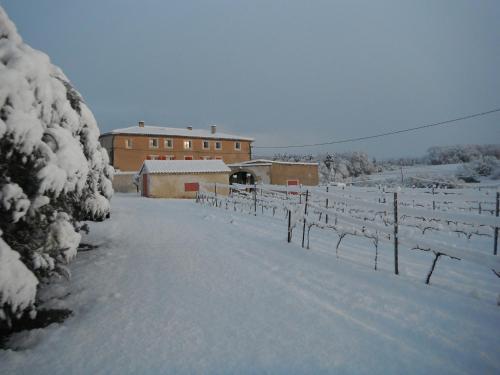 a snow covered field with a building in the background at Le Temps d'un Rêve in Mazan