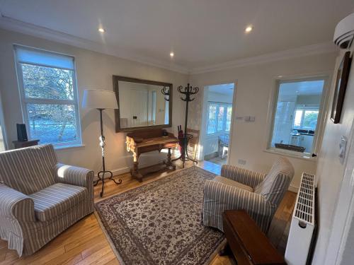 a living room with two couches and a mirror at Midsomer Cottage- Spacious Victorian Cottage with parking & garden - Close to City and ring road in Oxford