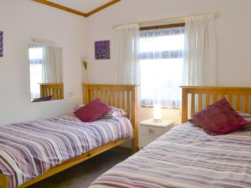um quarto com 2 camas e uma janela em Rosella em Bridekirk
