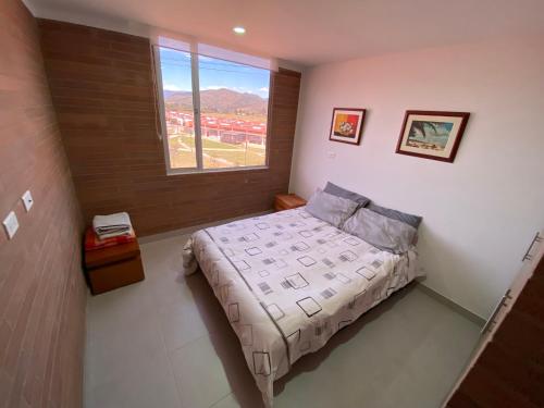 a small bedroom with a bed and a window at La toscana - Sogamoso in Sogamoso