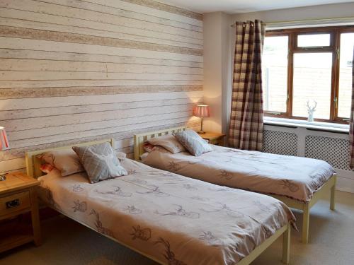 2 camas en una habitación con 2 ventanas en Ye Olde Smithy, en Burythorpe
