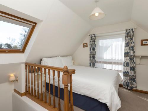 a bedroom with a bed and a window at Stable Cottage in Alnwick