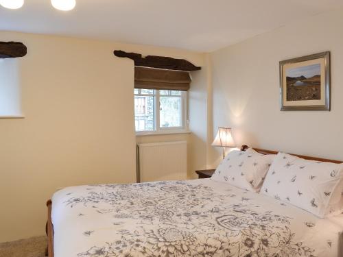 Schlafzimmer mit einem Bett und einem Fenster in der Unterkunft Meadow View in Hawkshead