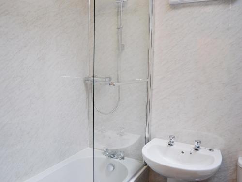 a bathroom with a glass shower and a sink at Sea-esta - 28175 in Port William