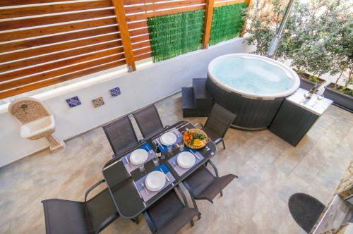 eine Terrasse mit einem Tisch und einem Whirlpool in der Unterkunft Al Mare in Porto Palo