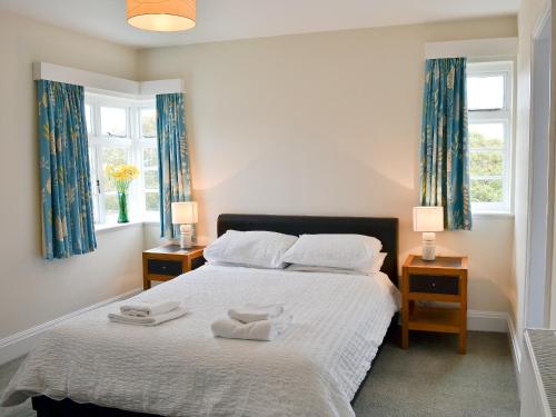 a bedroom with a bed with two towels on it at Windways in Port Erin