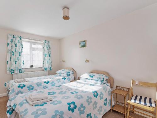a bedroom with two twin beds and a window at Peartree Farm Cottages - Rchm39 in Ebberston