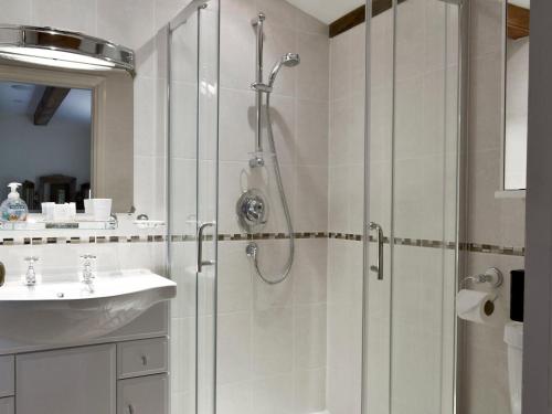 La salle de bains est pourvue d'une douche et d'un lavabo. dans l'établissement Walled Garden Lodge, à Ryhill