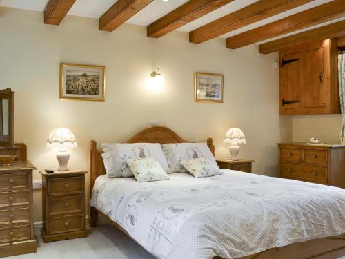 RyhillにあるWalled Garden Lodgeのベッドルーム1室(ベッド1台、ナイトスタンド2台、ランプ2つ付)