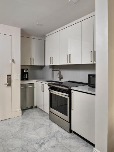 a kitchen with white cabinets and a stove top oven at AKA Central Park in New York