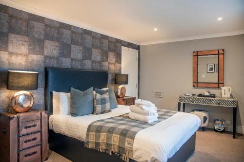 a bedroom with a large bed and a mirror at The Allan Park in Stirling