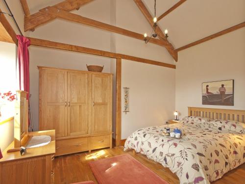 um quarto com uma cama e um armário de madeira em Timberway em Okehampton