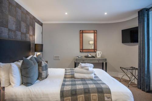a bedroom with a large white bed with blue pillows at The Allan Park in Stirling