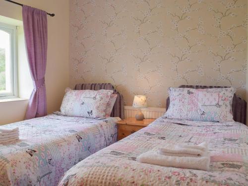 two beds sitting next to each other in a bedroom at Lower Mill Barn in Nantgaredig