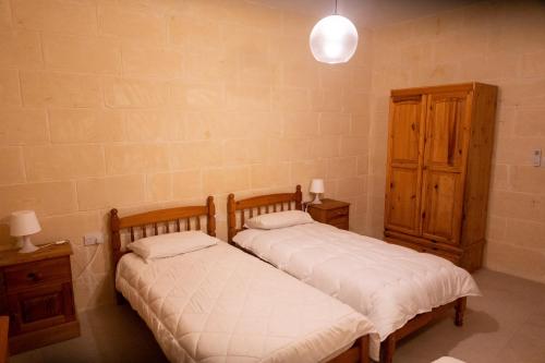 2 Betten nebeneinander in einem Zimmer in der Unterkunft Naduri Holiday Home in Taʼ Gorgun