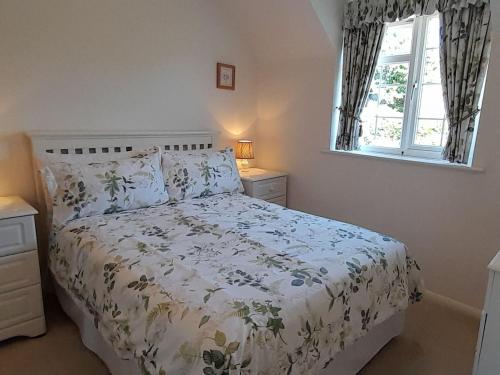 a bedroom with a bed and a window at Laurel Cottage in Sway