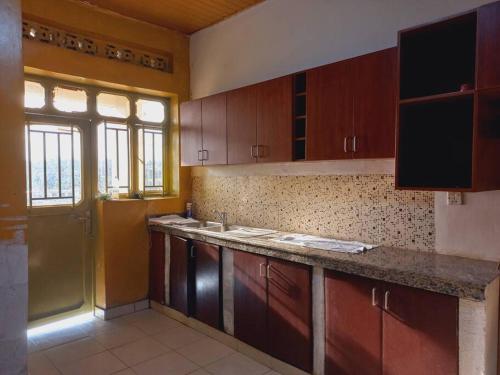 a kitchen with wooden cabinets and a counter top at Cheerful Villa Nyamata in Kayenzi