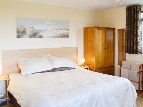 - une chambre avec un grand lit blanc et une chaise dans l'établissement Scholten Lodge, à Roche