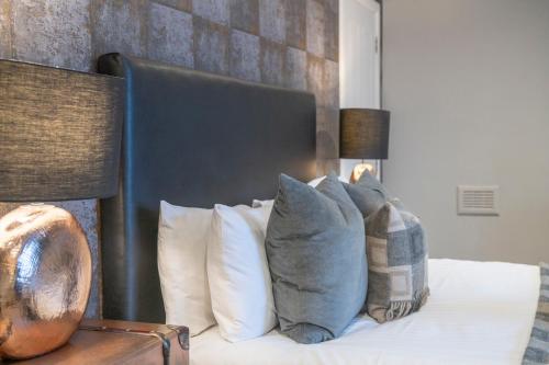 a bed with white pillows and a black head board at The Allan Park in Stirling