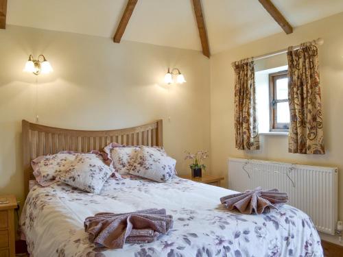 a bedroom with a bed with towels on it at Stable Cottage in East Meon