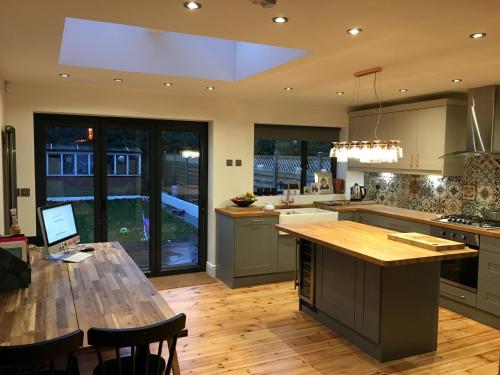 a kitchen with a large island with a wooden counter top at Three Bedroom Family home with garden in Walthamstow in London