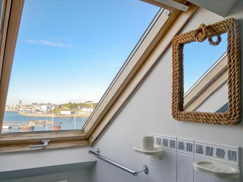 a bathroom with a window and a mirror on the wall at Providence Cottage in Turnchapel