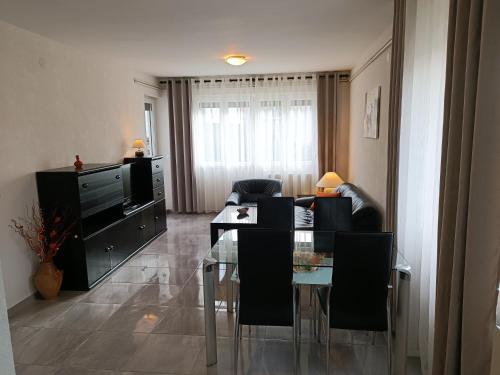 ein Wohnzimmer mit einem Tisch und einem TV in der Unterkunft Apartments Mira Krk in Krk