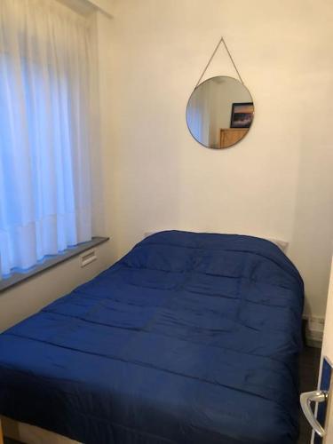 une chambre avec un lit bleu et un miroir dans l'établissement Le Tréport studio 2, au Tréport