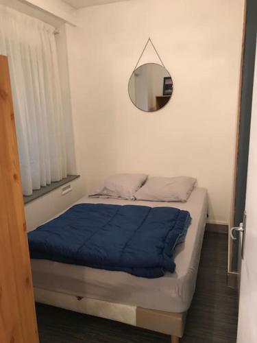 - une chambre avec un lit doté d'une couverture bleue et d'un miroir dans l'établissement Le Tréport studio 2, au Tréport