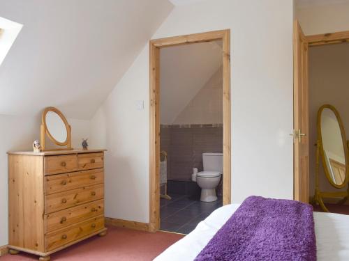 a bedroom with a bed and a bathroom with a toilet at The Stables - Uk5532 in Kepculloch