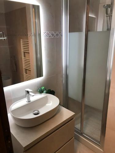 een badkamer met een witte wastafel en een douche bij Sunset house in Rosignano Marittimo