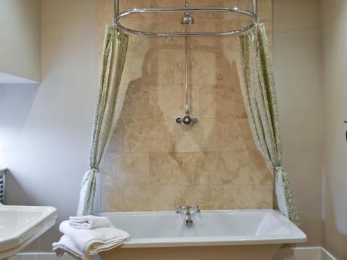 łazienka z wanną i umywalką w obiekcie Sykelands Cottage w mieście Ravensworth