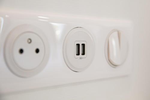 a white electrical outlet with two faces on it at Le Maleville - Appartements de Standing in Périgueux