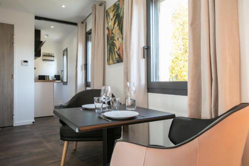jadalnia ze stołem i krzesłami oraz oknem w obiekcie Le Maleville - Balnéo & Ascenseur w mieście Périgueux