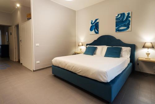 a bedroom with a bed with a blue headboard at Isula in Palermo